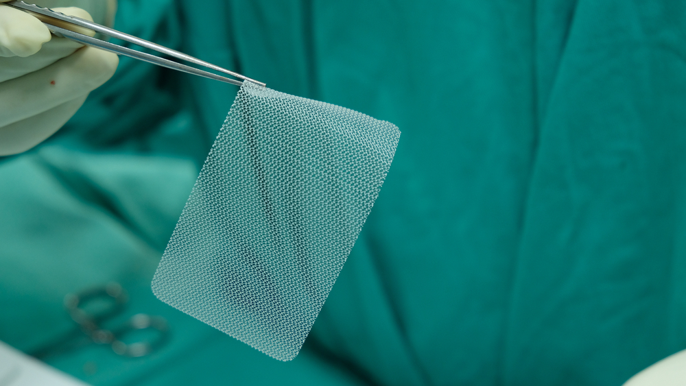 Surgeon holding up hernia mesh.