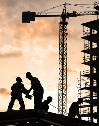 Silohuette of construction workers on a site.