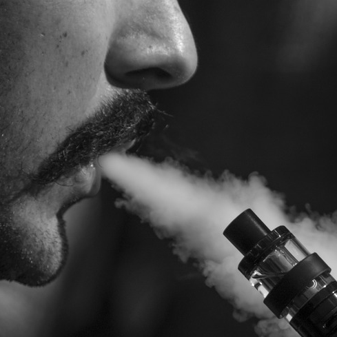 Man with e-cigarette vaping.