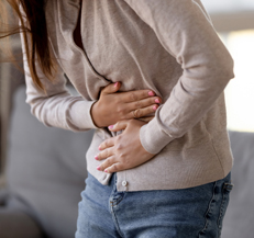 Woman experiencing stomach pain from hernia mesh implant.