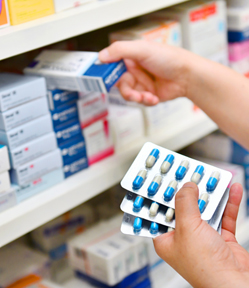 Pharmacist stocking shelves in a hospital pharmacy.